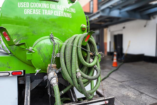 a technician pumping a grease trap in a commercial building in Fleetwood